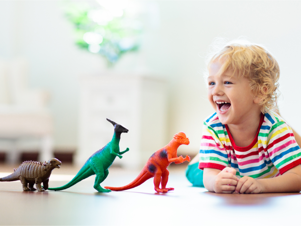 Niño sonriendo con sus juguetes | Bienestar infantil