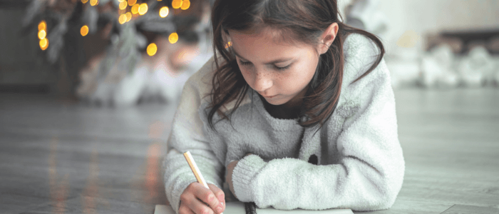 Niña escribiendo una carta a los Reyes Magos en Navidad Niña escribiendo una carta a los Reyes Magos en Navidad